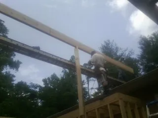 Carpenter setting a ridge beam over a new addition frame — Ice Dam Removal by Roofing Brothers in Vintondale