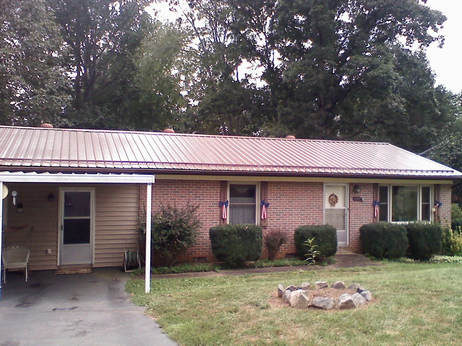 Bronze metal roof and carport on a brick ranch home — Roof Repair work by our crew in Vintondale